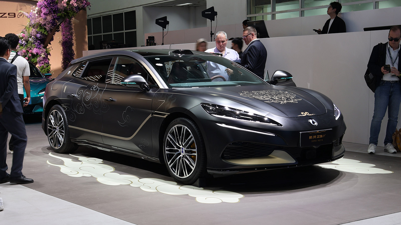 A black Denza Z9GT with gold decorative graphics on display at the 2026 Beijing auto show.
