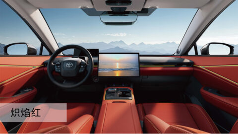 Interior of the 2027 Toyota bZ5 featuring red upholstery, a large central touchscreen and a multifunction steering wheel.