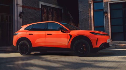 Side view of an orange Arcfox Alpha T7, showing its sloping roofline, flush door handles and black wheels.