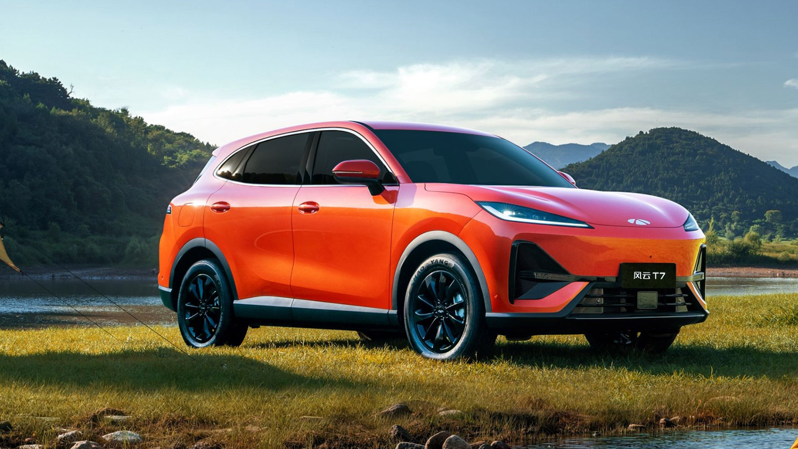 Orange Chery Fulwin T7 electric SUV parked beside a lake, shown from a front three-quarter angle.