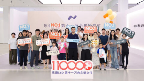 nvo staff and customers pose with signs at an event celebrating 110,000 cumulative deliveries of the L60 SUV.