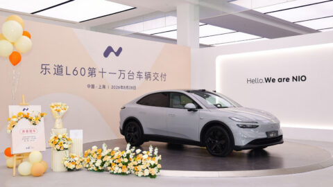 A gray Onvo L60 displayed with flowers and balloons at a ceremony marking 110,000 cumulative deliveries.