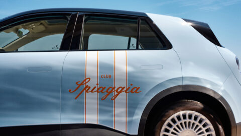 Close-up of the Nio Firefly Club Spiaggia’s orange lettering and striped decals across the side doors.