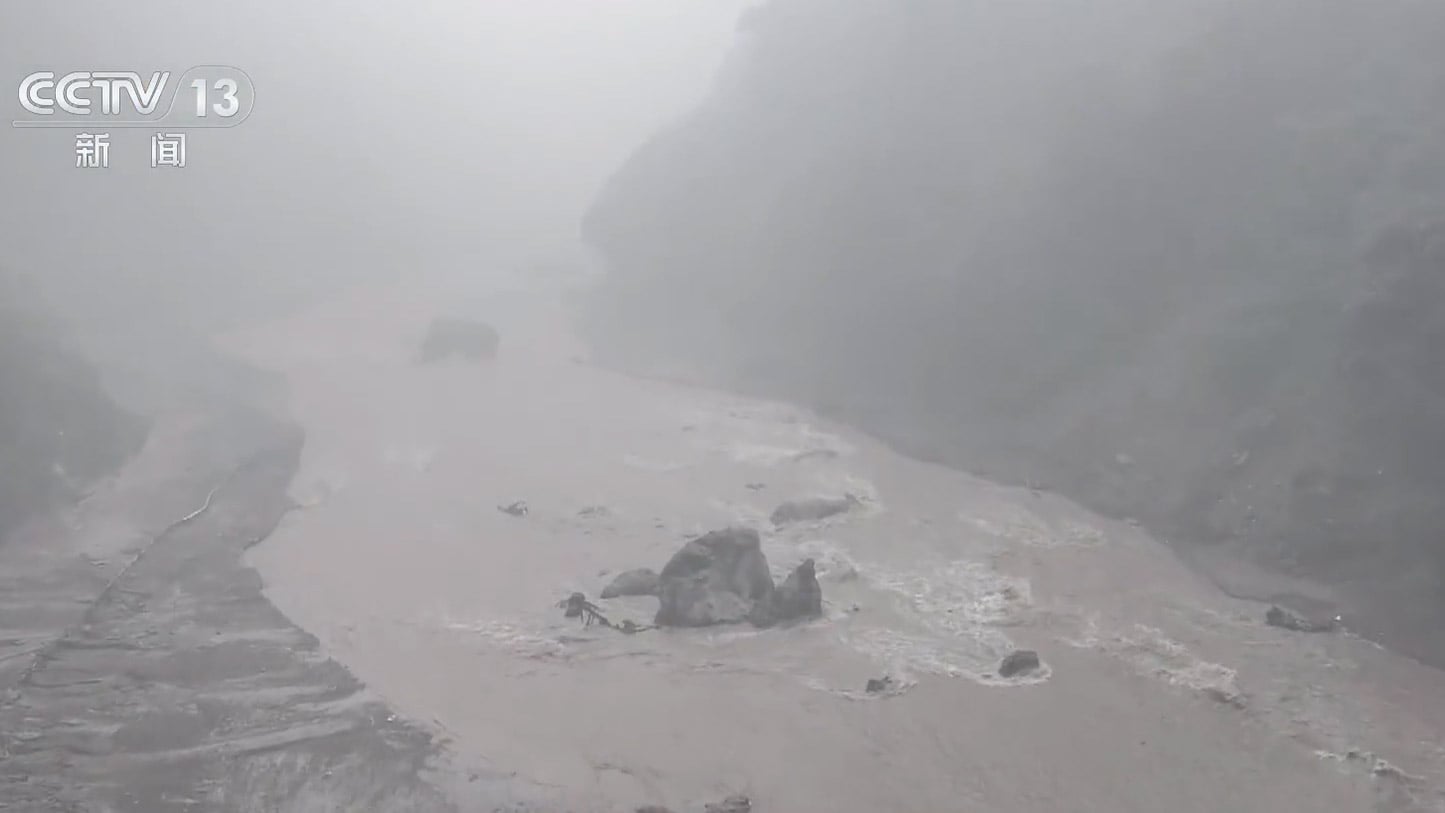 Muddy floodwater and debris fill a mountain valley near Gyirong Port in Xizang following a mudslide.