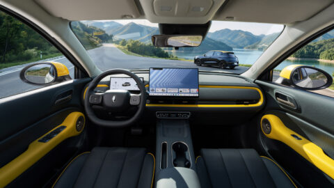 Interior of the GWM Ora 5 Sport featuring a digital instrument cluster, a large central touchscreen and yellow trim.