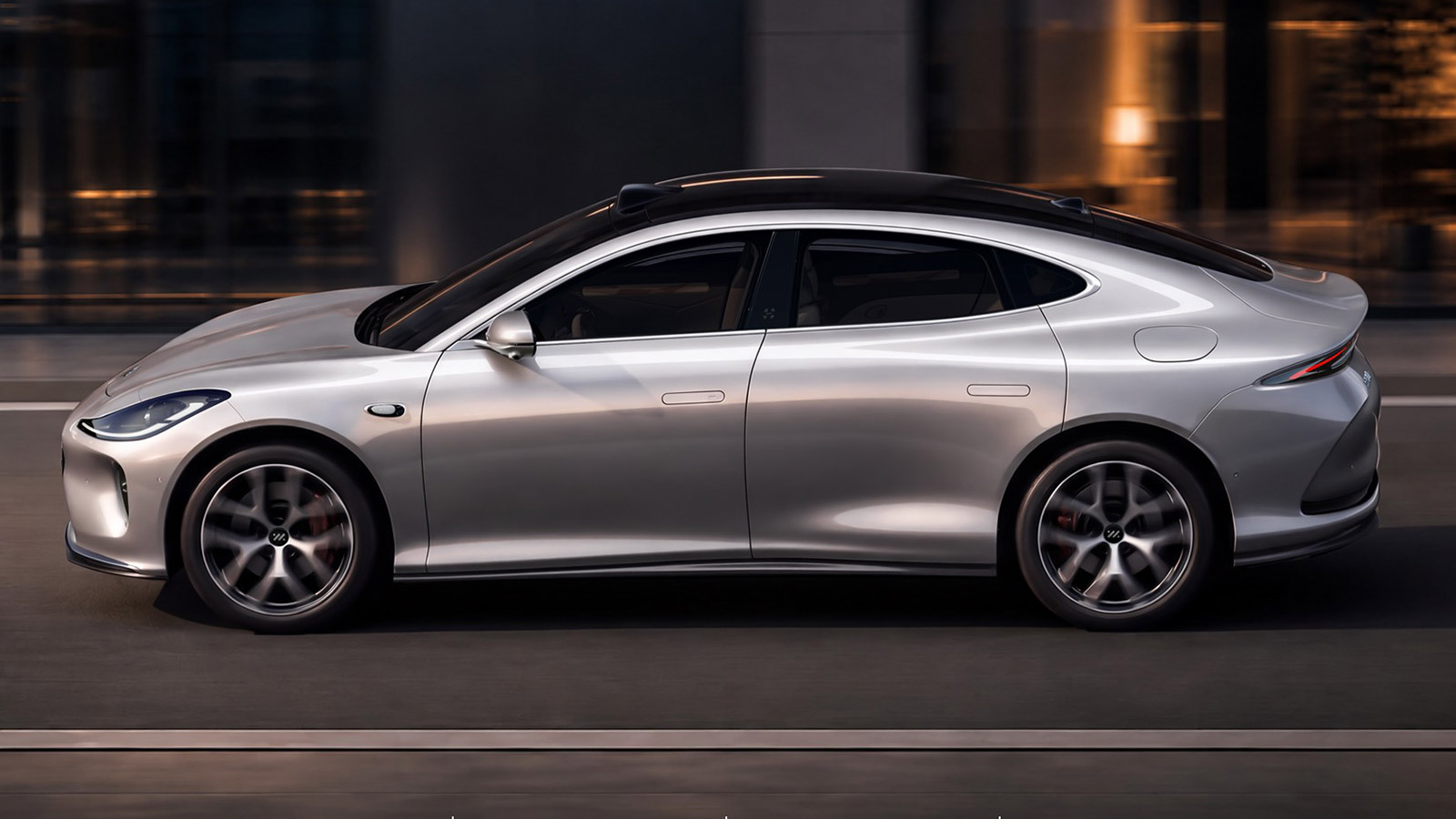 Side view of the all-new silver IM L6 electric sedan driving at night.
