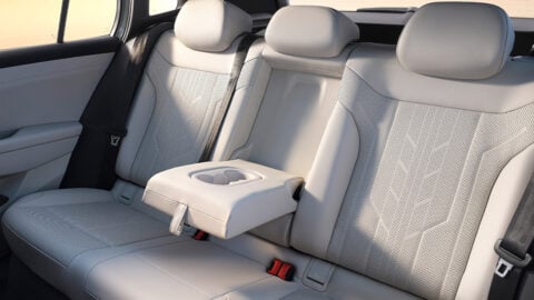 Rear seating area of the FAW-Volkswagen ID. AURA T6 with light-colored upholstery and a fold-down center armrest with cupholders.