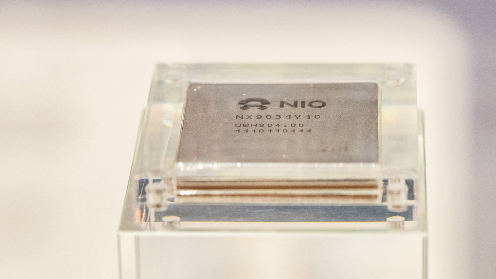 A Nio Shenji NX9031 smart-driving chip displayed in a transparent case at the Beijing Auto Show in April 2026.