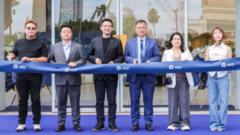Representatives of Nio and Guangdong Hongyue Automobile Group hold a ribbon-cutting ceremony outside Nio House Macau.