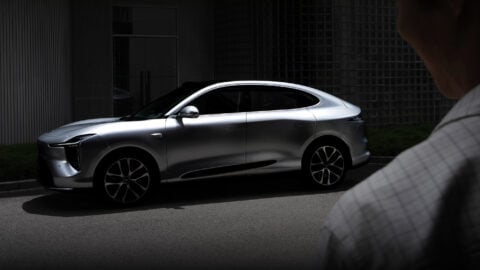 Front three-quarter view of the all-new silver IM LS6 SUV parked outside a modern building.