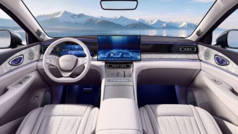 Front cabin of the BYD Sealion 08 featuring pale upholstery, a digital instrument cluster, a large central touchscreen and a center console.