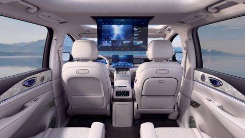 View toward the front of the BYD Sealion 08 cabin showing pale seats, the central touchscreen and a roof-mounted rear entertainment display.