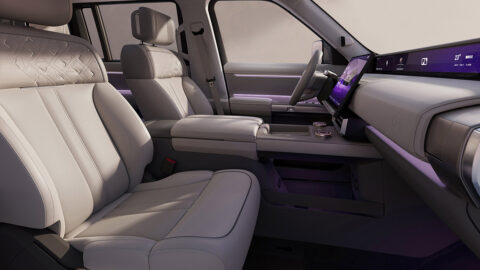 Front seats and dashboard of the Freelander 8, featuring light-colored upholstery and purple ambient lighting.