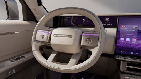 Close-up of the Freelander 8 cockpit showing the steering wheel, panoramic dashboard display and central touchscreen.