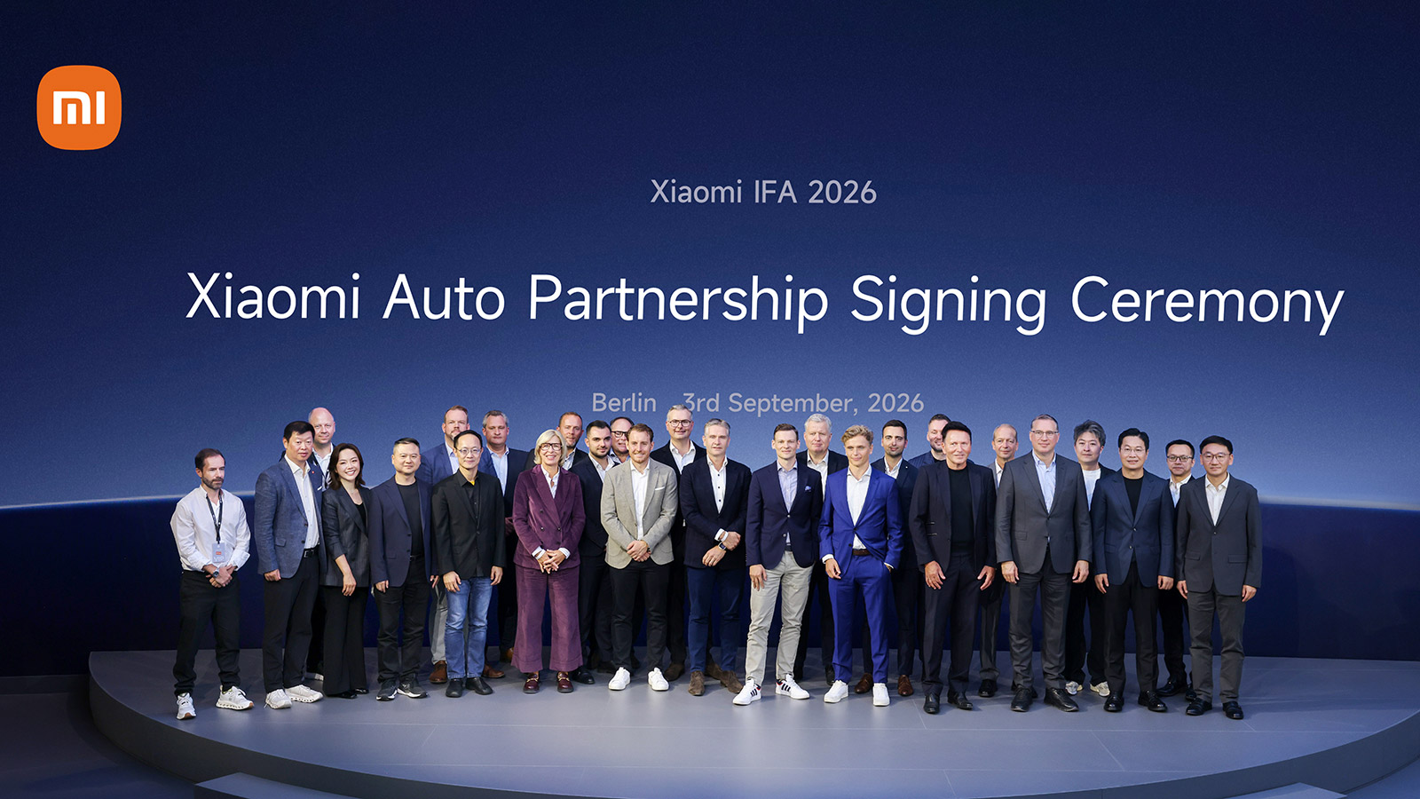 Representatives from Xiaomi Auto and 8 German automotive dealer groups pose onstage at a partnership signing ceremony during IFA Berlin 2026.