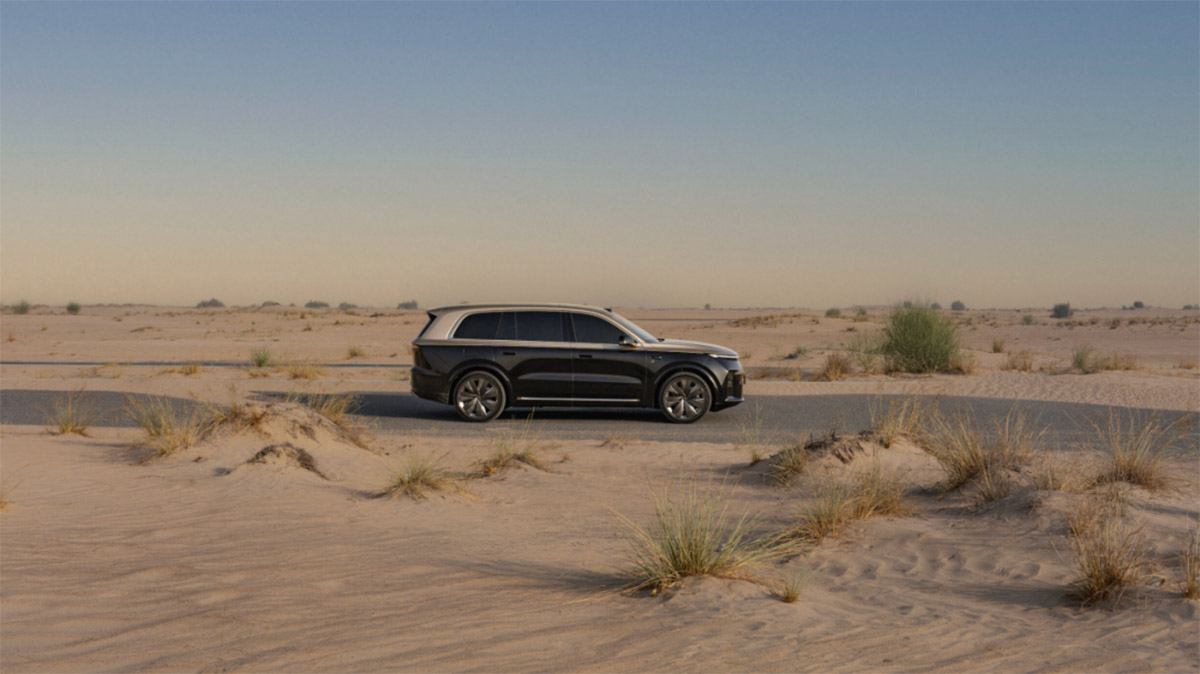 A black Li L9 traveling on a paved road through a desert landscape in the UAE.