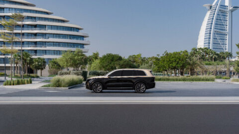 A black Li L9 driving through Dubai with the Burj Al Arab visible in the background.