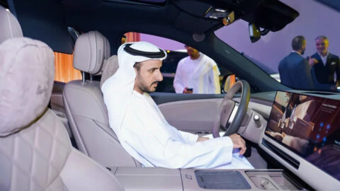 A man in traditional Emirati attire seated in the driver's seat of a Li L9 and looking at its dashboard display.