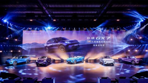 Five Aistaland GX7 SUVs are displayed under spotlights onstage at the model’s presale launch event.