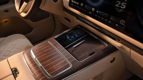 Voyah Dream 9 center console with wood trim, a wireless phone-charging pad and a wide dashboard display.