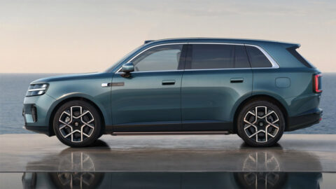 Side profile of a green Xiaomi Sky Nomad N70 SUV beside the sea, showing its window trim and side step.