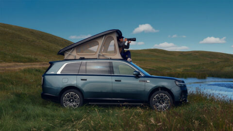 Xiaomi Sky Nomad N90 Max Explorer edition parked beside a lake, with a photographer using its raised pop-top roof.