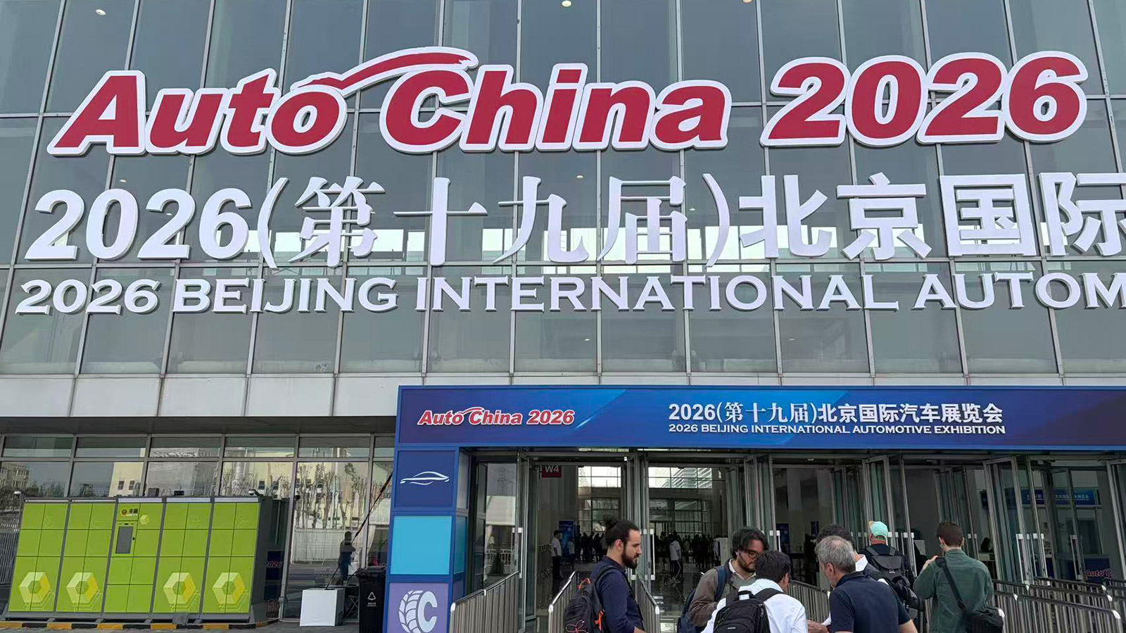Visitors outside an entrance to the 2026 Beijing Auto Show beneath large Auto China 2026 signage.