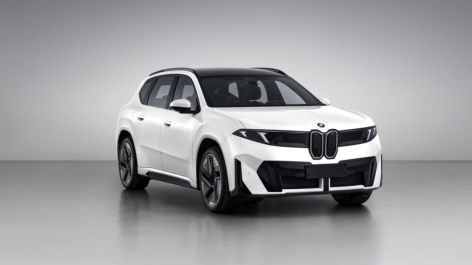 Front three-quarter view of a white BMW Neue Klasse iX3 30L electric SUV with a black roof and twin kidney grille.