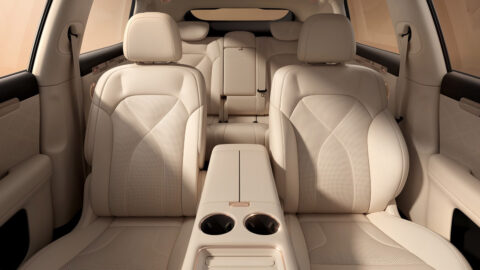 Beige front and rear seats inside the updated IM LS6, with a center armrest and 2 cupholders between the front seats.