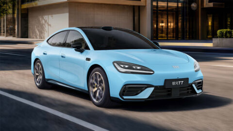 Light blue Geely Galaxy TT driving along a city street, viewed from the front three-quarter angle with roof-mounted LiDAR visible.