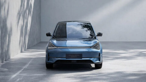 Front view of the blue Zotye Wink Y01 international edition, showing triangular headlights and a connecting LED light strip.