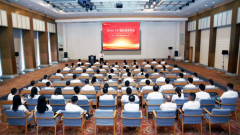 Attendees listen to a presentation at Zotye’s Wink Y01 international edition event in a conference hall.