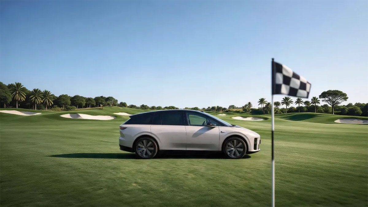 Side view of a silver Li i6 electric SUV on a golf course, with a checkered flag in the foreground.