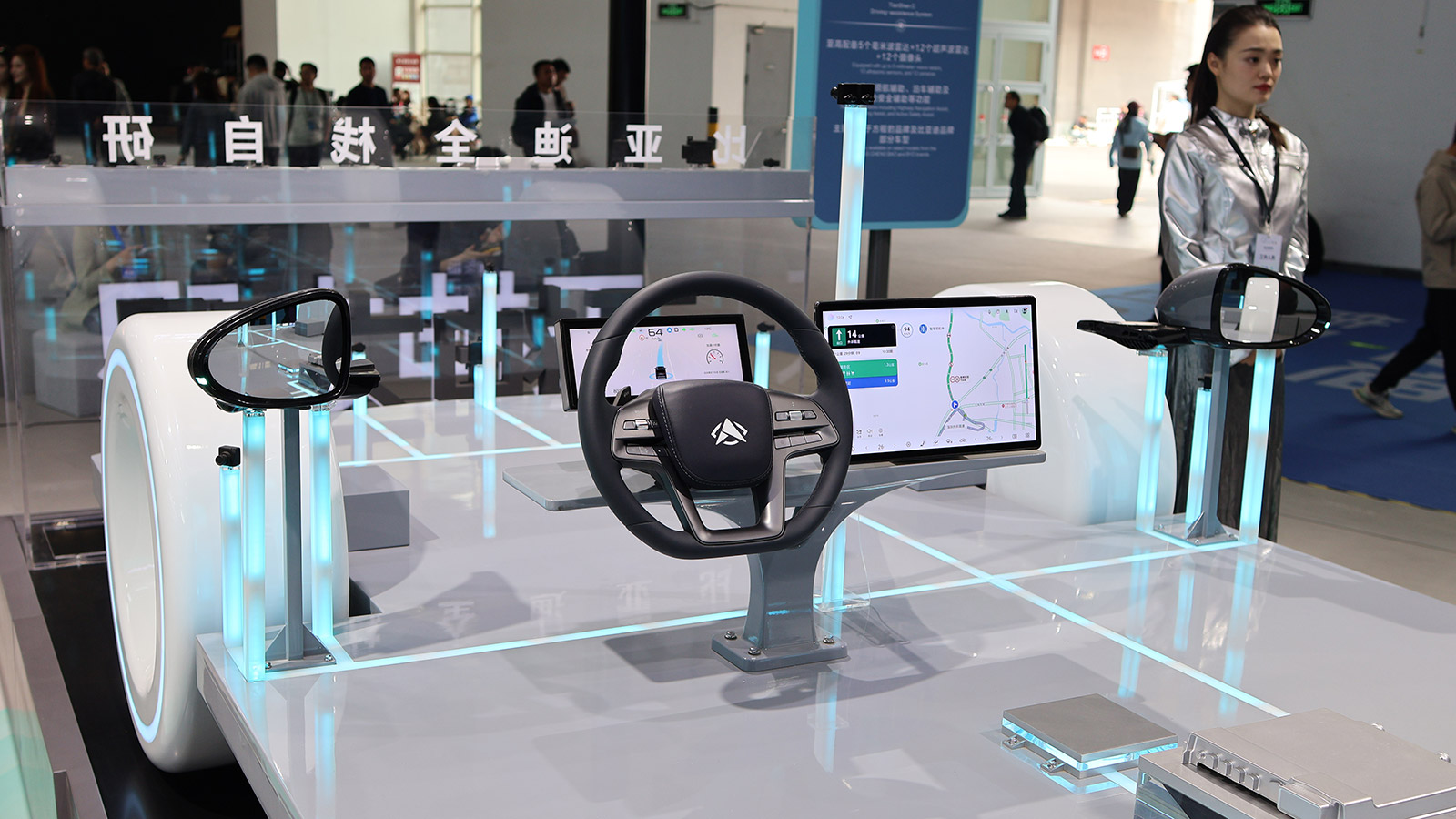 BYD autonomous driving prototype with an exposed steering wheel, digital displays and sensors at the 2026 Beijing Auto Show.