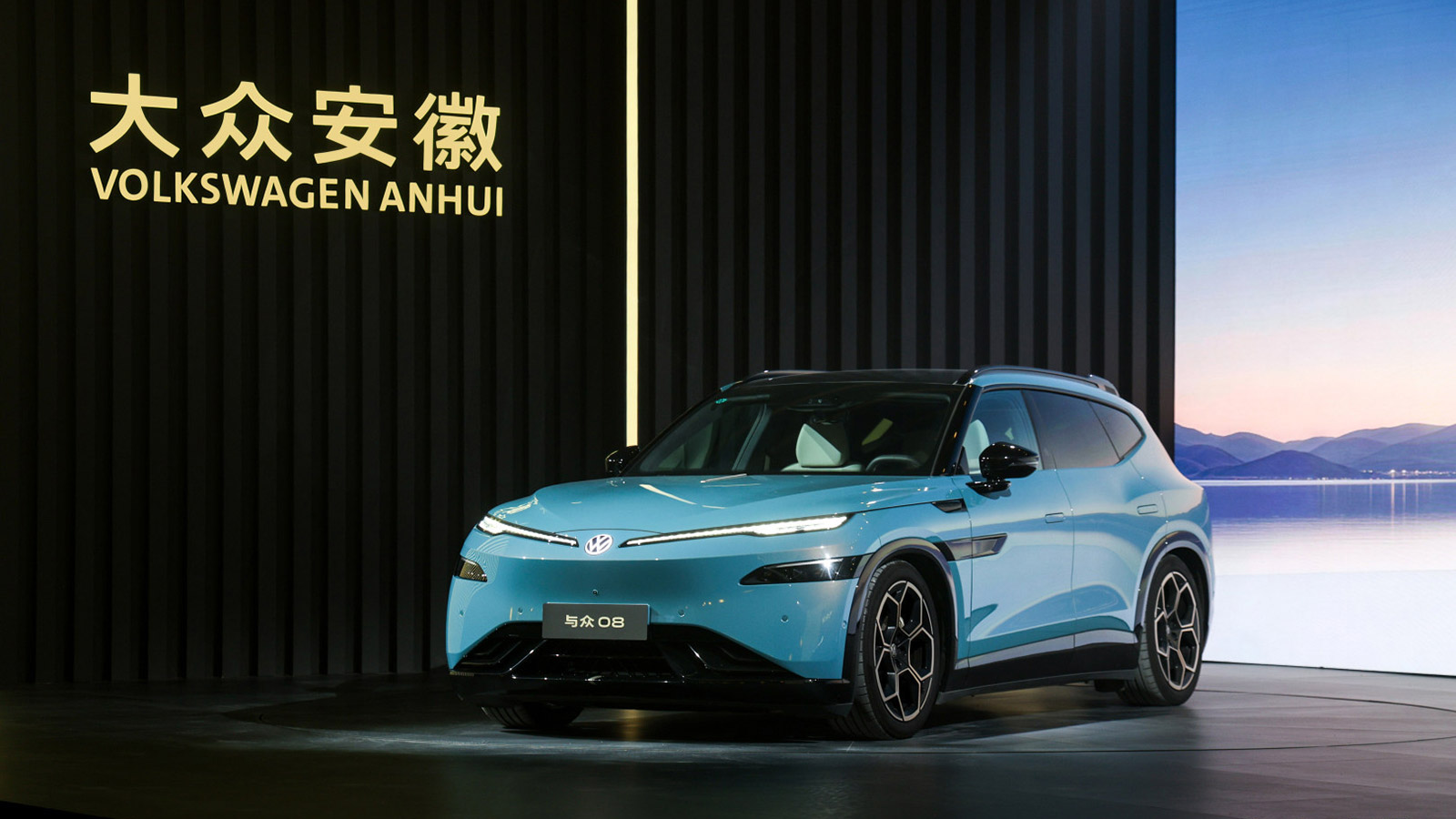 Blue Volkswagen ID. UNYX 08 electric SUV displayed on stage, viewed from the front three-quarter angle.