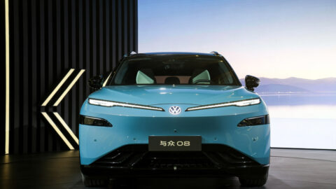 Front view of a blue Volkswagen ID. UNYX 08 with illuminated LED running lights and Volkswagen badge.