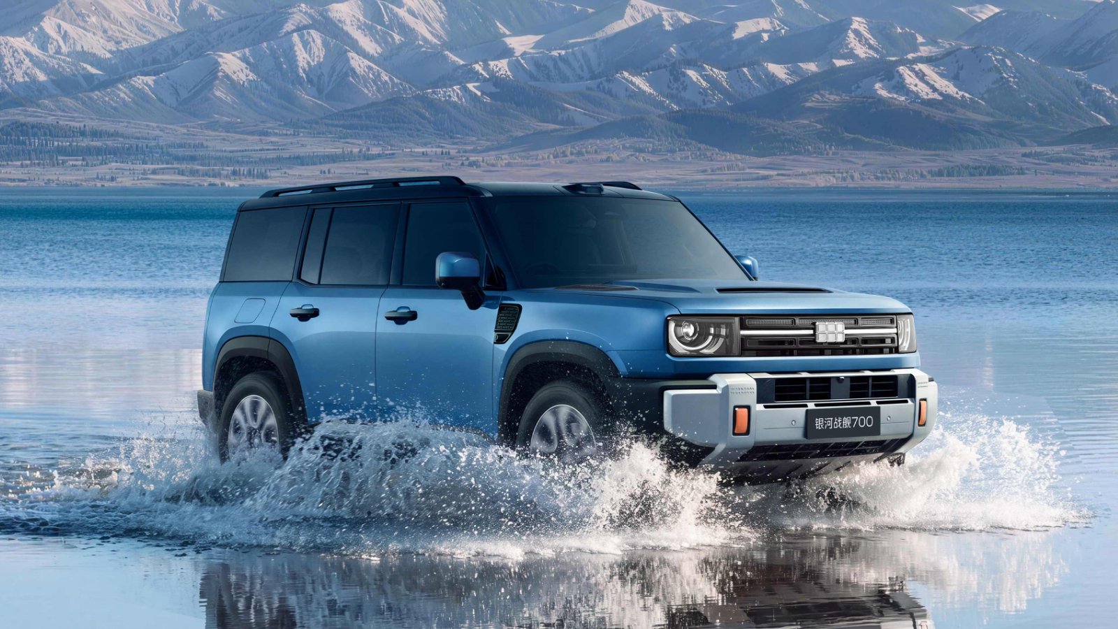 Blue Geely Galaxy Cruiser 700 driving through shallow water, with a lake and snow-covered mountains in the background.