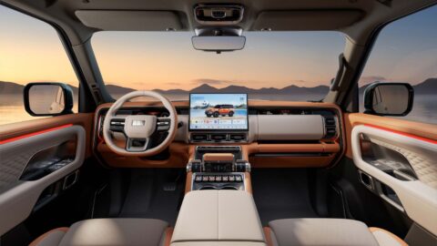 Geely Galaxy Cruiser 700 cockpit with a central touchscreen, wide dashboard display, physical controls, and orange-and-cream trim.