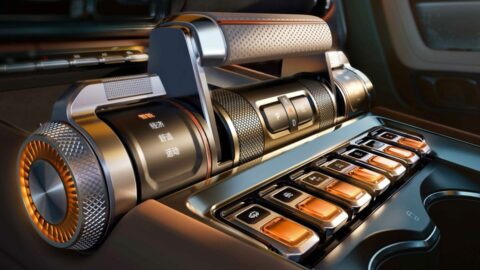 Close-up of the Geely Galaxy Cruiser 700's gear selector, rotary driving-mode control, and orange-accented physical switches.