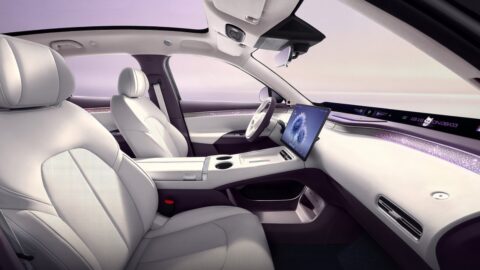 Arcfox Alpha T7 front cabin showing white seats, a central touchscreen, center console and panoramic dashboard display.