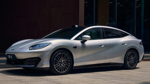 Silver Fang Cheng Bao Formula S electric sedan viewed from the front three-quarter angle outside a building.