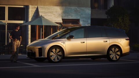 Gold Li i9 electric SUV parked outside a building, showing its side profile and black roof.