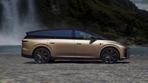 Gold Li i9 electric SUV parked near a waterfall, with dark alloy wheels and a contrasting black roof.