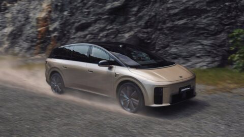 Front three-quarter view of a Li i9 electric SUV driving along a gravel road beside a rocky cliff.