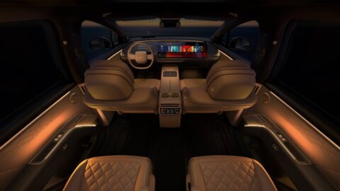 Li i9 cabin viewed from the rear, showing tan seats, ambient lighting and the panoramic dashboard display.