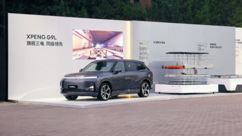 Gray Xpeng G9L displayed beside an exploded battery pack exhibit and information panels about its battery technology.