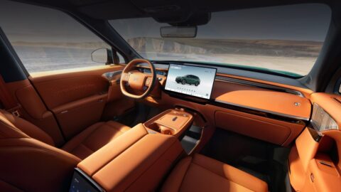 Xpeng G9L front cabin with orange upholstery, a central touchscreen, a digital instrument cluster and a floating center console.