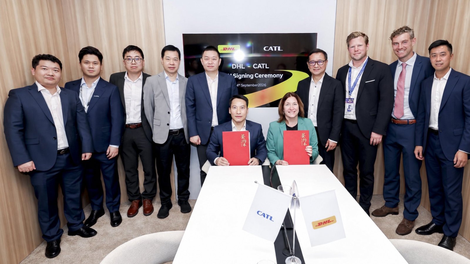 CATL and DHL representatives pose with red agreement folders at a signing ceremony in Hanover, Germany.