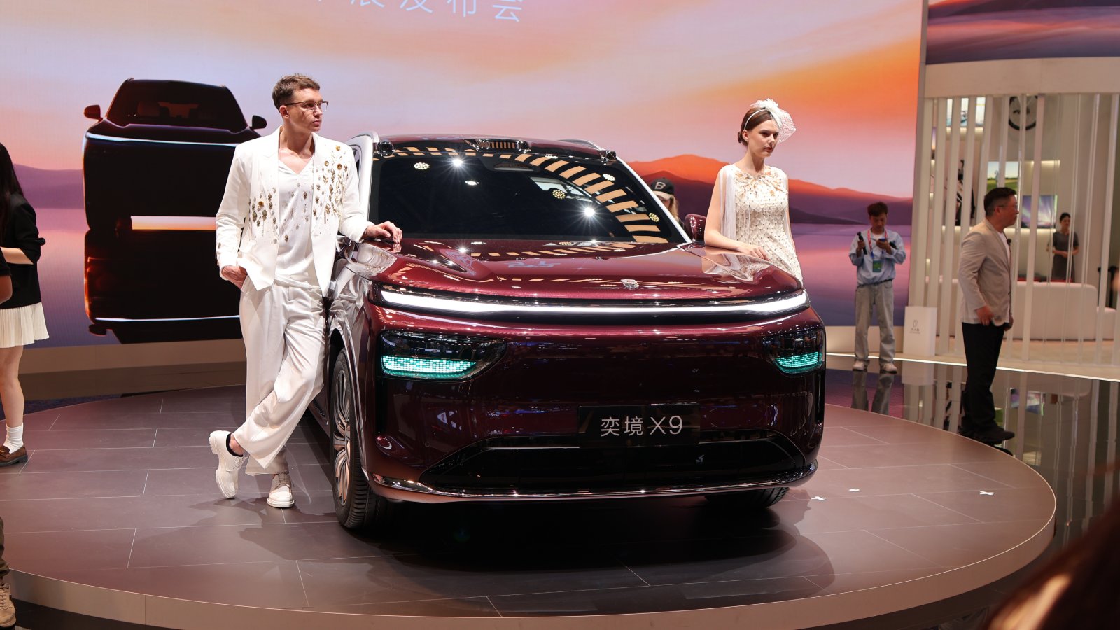 Burgundy Epicland X9 SUV displayed with 2 models at the Beijing Auto Show in April 2026.