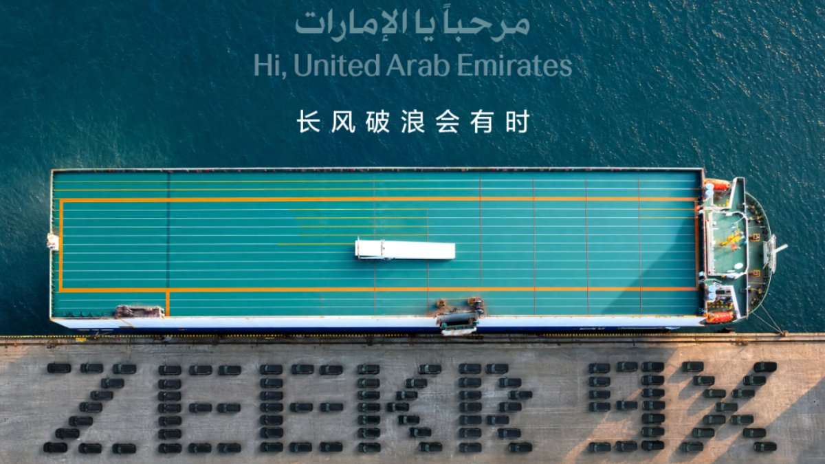 Aerial view of Zeekr 9X SUVs arranged to spell “ZEEKR 9X” beside a docked ship, with a greeting to the UAE above.